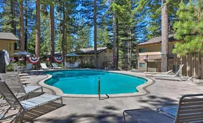 a swimming pool with chairs and a house at Tahoe Townhome-Lake-Beach-Pool-Amenities in Incline Village