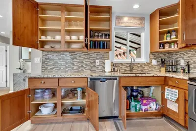 a kitchen with wooden cabinets and a sink at Reno Retreat-Near Downtown-UNR-Family Fun in Reno