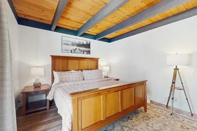 a bedroom with a large bed with a wooden headboard at Cozy Bear Retreat in Kings Beach