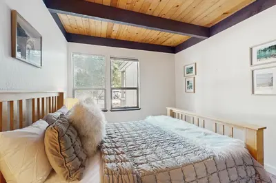 a bedroom with a bed and two windows at Cozy Bear Retreat in Kings Beach