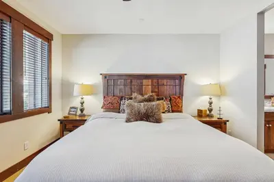 a bedroom with a large white bed with two lamps at TruckeeTime in Truckee