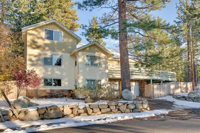 a house with a stone fence in front of it at Sequoia Chalet home in Stateline