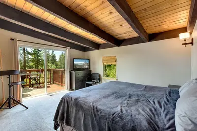 a bedroom with a large bed and a balcony at Cold Creek Lodge home in South Lake Tahoe