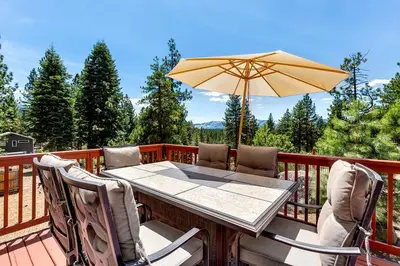 a table and chairs with an umbrella on a deck at Cold Creek Lodge home in South Lake Tahoe