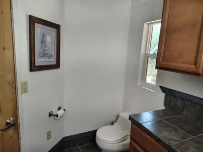 a bathroom with a toilet and a window at Dew Drop Inn Kings Canyon National Park in Miramonte
