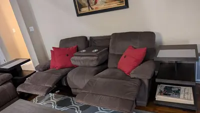 a brown couch with red pillows in a living room at Tanglewood Place in Visalia