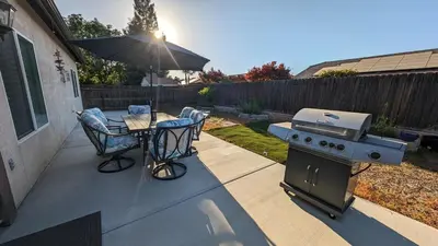 a patio with a grill and a table and chairs at Tanglewood Place in Visalia