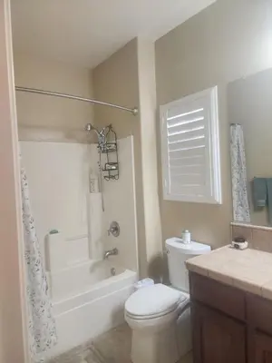 a bathroom with a toilet and a tub and a sink at Tanglewood Place in Visalia