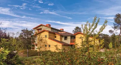 a yellow house in the middle of a field at Wyndham Angels Camp 1BR Apartment with Resort Access in Angels Camp