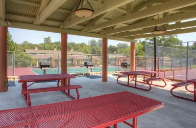 a patio with picnic tables and a pool at Wyndham Angels Camp 1BR Apartment with Resort Access in Angels Camp
