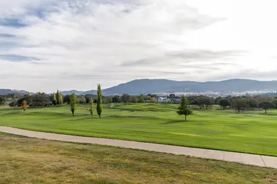 a view of a golf course with trees and a sidewalk at Wyndham Angels Camp 2BR Apartment with Resort Access in Angels Camp