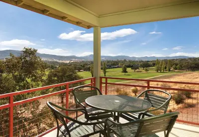 a patio with a table and chairs on a balcony at Wyndham Angels Camp 3BR Apartment with Resort Access in Angels Camp