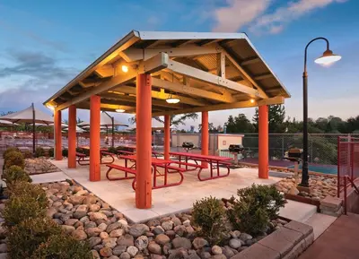 a pavilion with red picnic tables in a park at Wyndham Angels Camp 3BR Apartment with Resort Access in Angels Camp