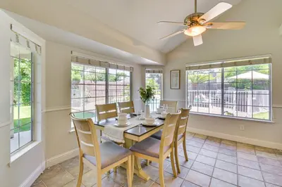 a dining room with a table and chairs and windows at Clovis Family Home Private Pool, Near Old Town! in Clovis