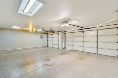 an empty garage with white garage doors and a window at Clovis Family Home Private Pool, Near Old Town! in Clovis