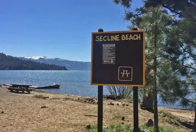 a sign on a beach near a body of water at #9 Lakeside Location Beach Access View BalconyDog in Kings Beach