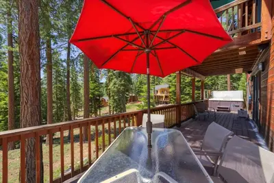 a red umbrella sitting on the deck of a house at Wooded Escape in Tahoe Vista Private Hot Tub in Tahoe Vista