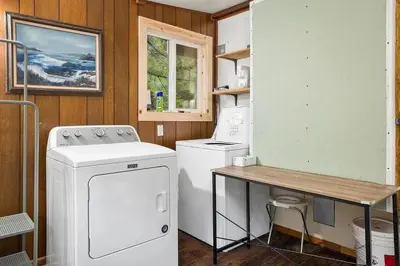 a laundry room with a washing machine and a table at Stay At 4K in Arnold