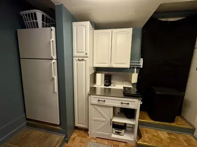 a small kitchen with white cabinets and a refrigerator at 1br 1ba private ADU in Sacramento