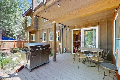 a wooden deck with a stove and a table at Serenity Summit in South Lake Tahoe