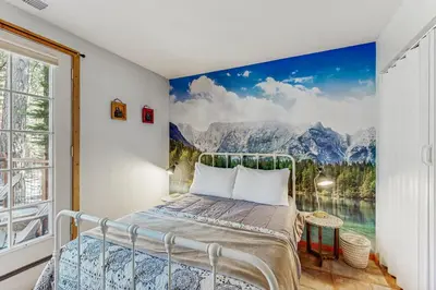 a bedroom with a bed with a painting on the wall at The Rikz Cabin in South Lake Tahoe