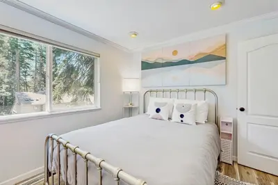 a white bedroom with a bed and two windows at Mountain Serenity in Incline Village