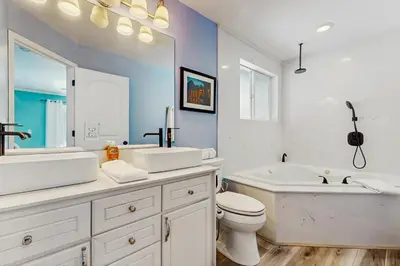 a white bathroom with a tub and a toilet and a sink at Mountain Serenity in Incline Village