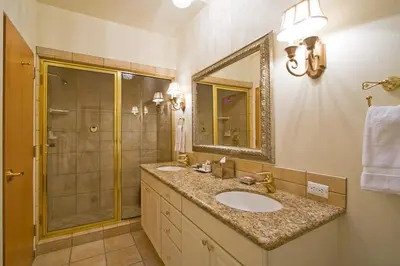 a bathroom with a sink and a shower and a mirror at Downtown Penthouse condo in South Lake Tahoe