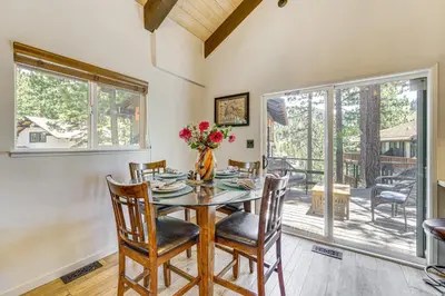 a dining room with a table and chairs and windows at Walk to Diamond Peak Luxe Chalet with Mtn-View Deck in Incline Village