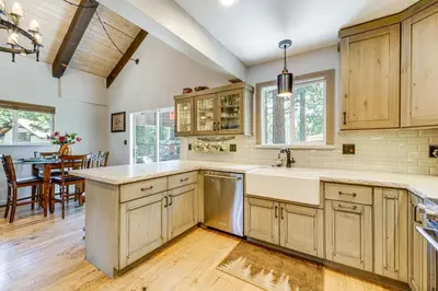 a kitchen with wooden cabinets and a dining room at Walk to Diamond Peak Luxe Chalet with Mtn-View Deck in Incline Village