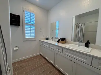 a white bathroom with two sinks and a mirror at Joyhouse in Visalia