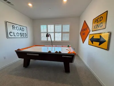 a room with a pool table and signs on the wall at Joyhouse in Visalia
