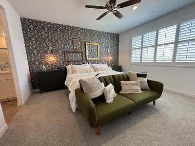a bedroom with a bed and a green couch at Joyhouse in Visalia