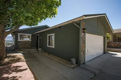 a green house with a white garage at Special Rates-Skyline Escape-Reno-UNR-Tahoe in Reno