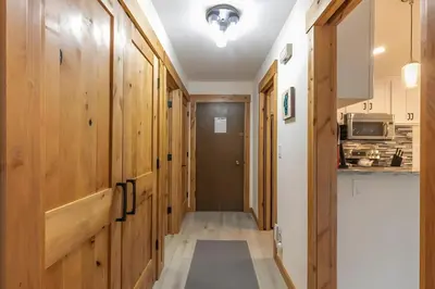 a hallway with wood paneled walls and a kitchen at 1BDR Condo in the Heart of Olympic Valley! in Tahoe City