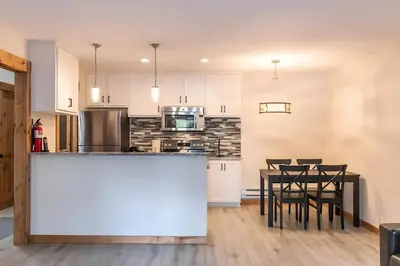 a kitchen and dining room with a table and chairs at 1BDR Condo in the Heart of Olympic Valley! in Tahoe City