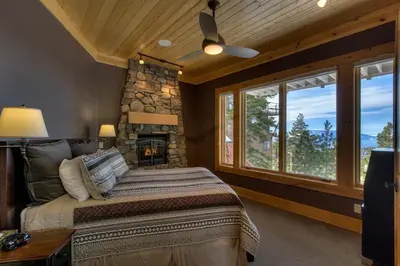 a bedroom with a large bed and a stone fireplace at Rock Haven condo in Stateline