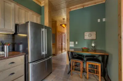a kitchen with a stainless steel refrigerator and a table at Rock Haven condo in Stateline