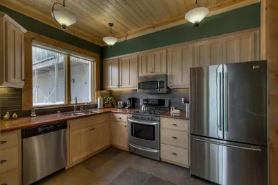 a kitchen with a stainless steel refrigerator and wooden cabinets at Rock Haven condo in Stateline
