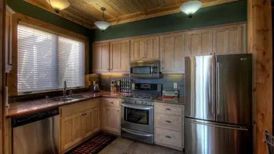 a kitchen with wooden cabinets and a stainless steel refrigerator at Rock Haven condo in Stateline