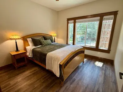a bedroom with a large bed and a window at Black Bear Bungalow in White Wolf