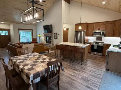 a kitchen and living room with a table and chairs at Black Bear Bungalow in White Wolf