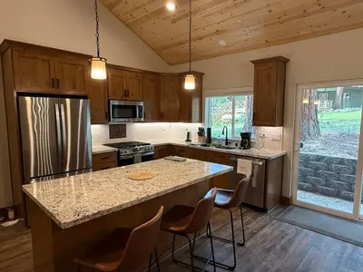 a kitchen with a large island with bar chairs at Black Bear Bungalow in White Wolf