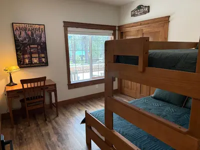 a bedroom with two bunk beds and a desk at Black Bear Bungalow in White Wolf