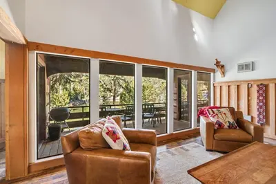 a living room with two chairs and a large window at The Lake Chalet in Bear Valley