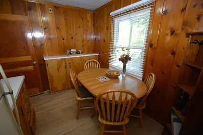 a dining room with a wooden table and chairs at Lakeside Cabin with lake view in Bass Lake