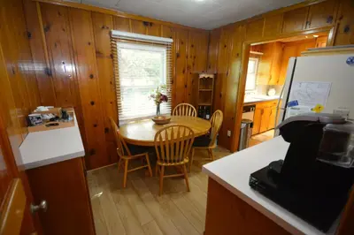 a kitchen and dining room with a table and chairs at Lakeside Cabin with lake view in Bass Lake