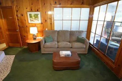 a living room with a couch and a coffee table at Lakeside Cabin with lake view in Bass Lake