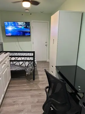 a living room with a bench and a tv on the wall at Macau Studio-Guesthouse by Sac State and UCDMC in Sacramento