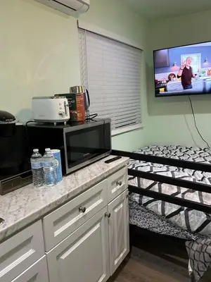 a small room with a bed and a tv at Macau Studio-Guesthouse by Sac State and UCDMC in Sacramento